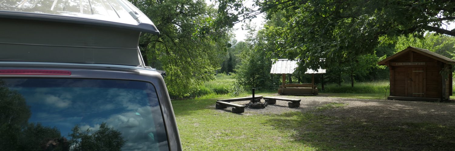 Bulli mit aufgestelltem Hochdach auf Campingsite mit Feuerstelle und Wasserzugang Somoo NP